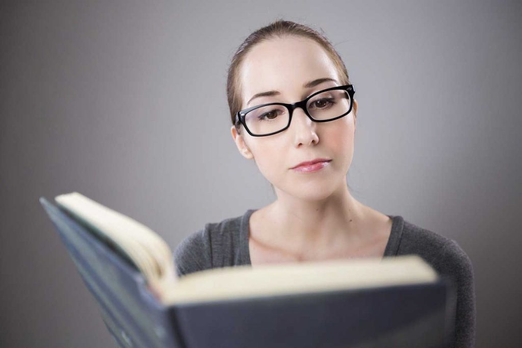 une femme avec des nouvelles lunettes et qui lit un livre