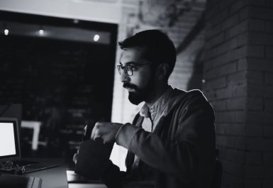 Un homme qui mange le soir devant son PC