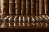 Photographie en tons sépia présentant une collection de dentiers vintage soigneusement disposés sur une table en acajou polie, avec en fond des journaux médicaux reliés en cuir usé, éclairage doux et ambiance antique en 4k.