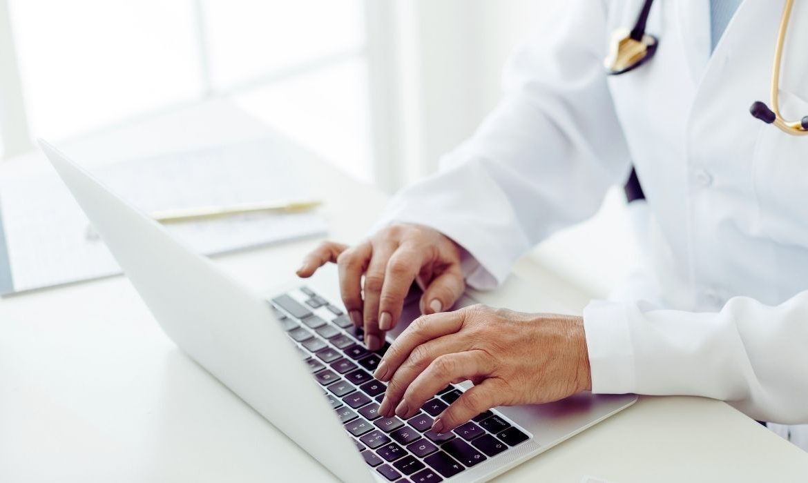 Un médecin qui tapote sur son ordinateur
