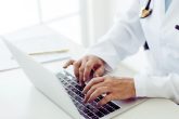 Un médecin qui tapote sur son ordinateur