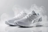 Des baskets de sport en gros plan sont posées sur une surface propre, enveloppées d’un nuage de spray anti-transpirant.