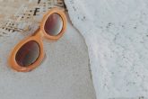 Paire de lunettes de soleil posee sur le sable d'une plage en ete