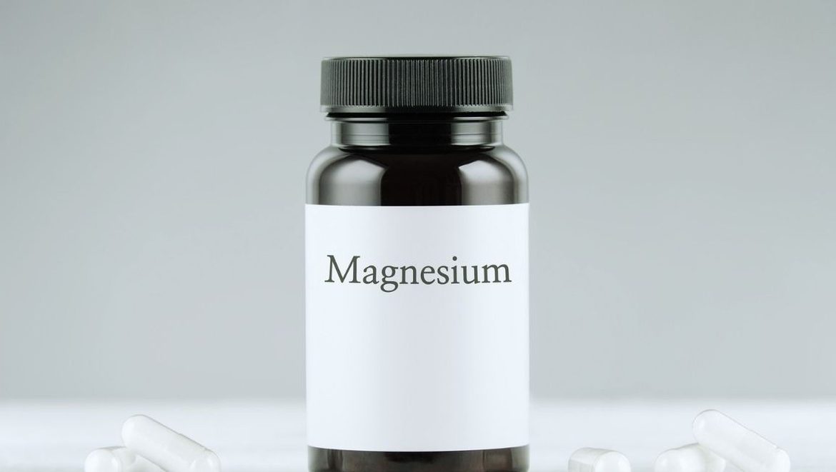 Flacon de complément alimentaire au magnésium entouré de gélules blanches